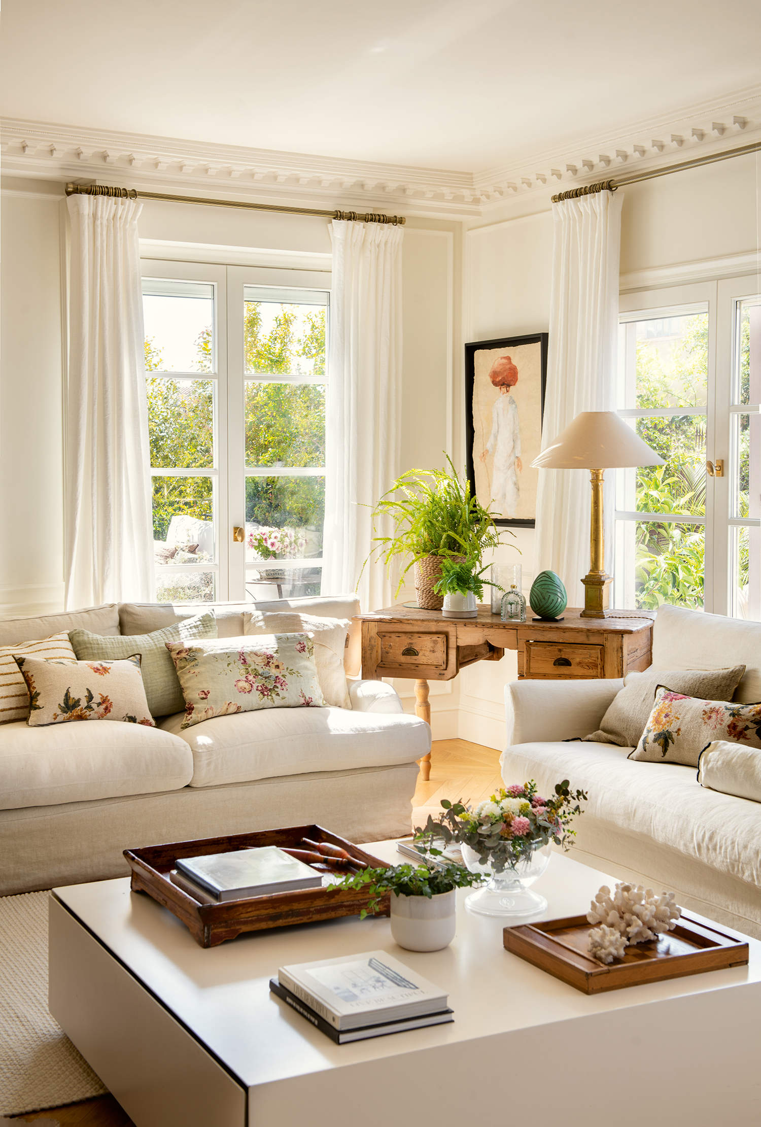 Salón elegante y luminoso con sofás blancos, mesa de centro blanca, cortinas